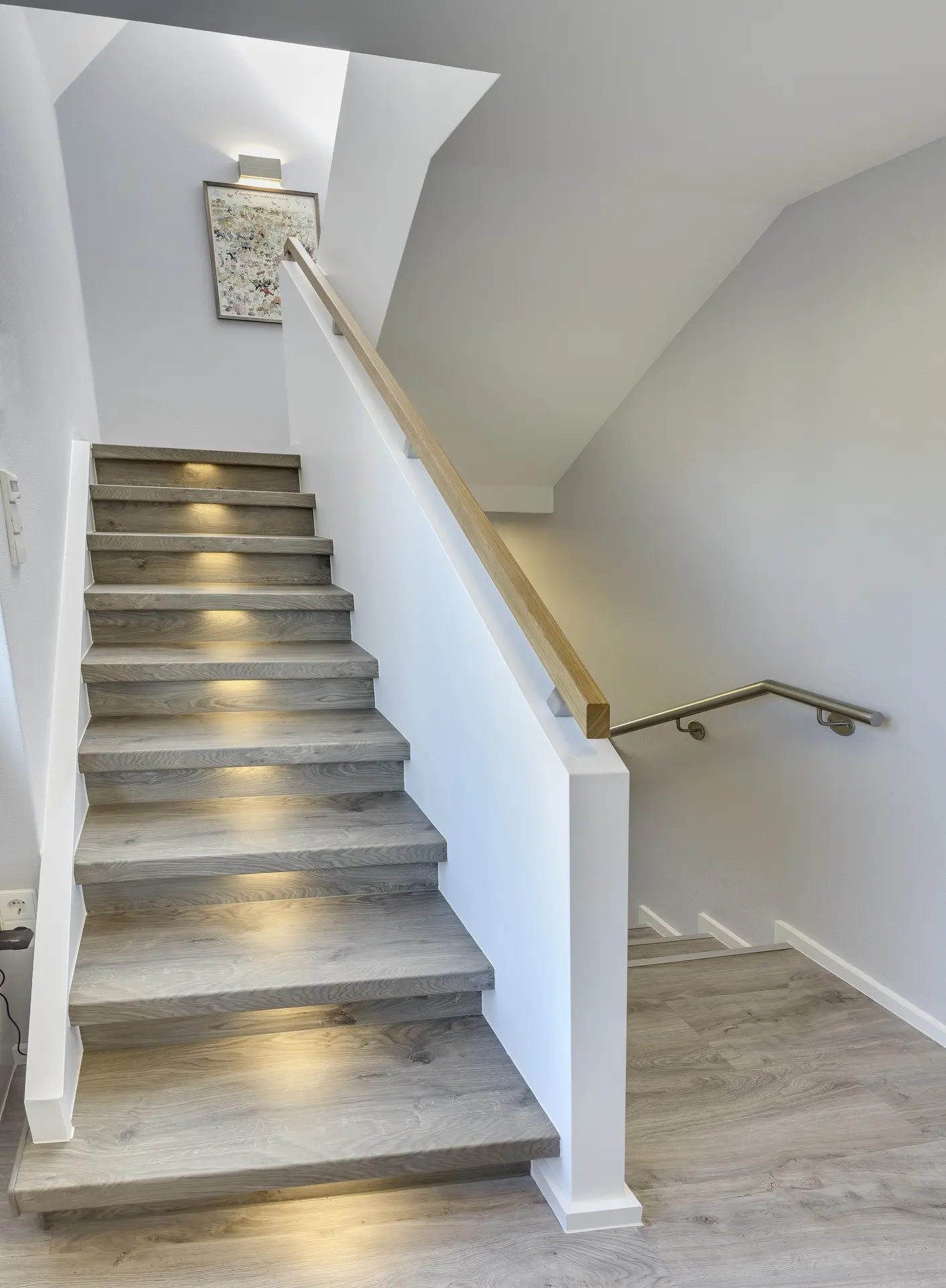 Treppe mit Holzstufen, Stufenbeleuchtung und Eichenhandlauf